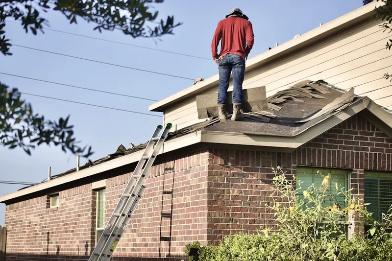Professional roofer working on a residential roof in Treehill Park Condominiums